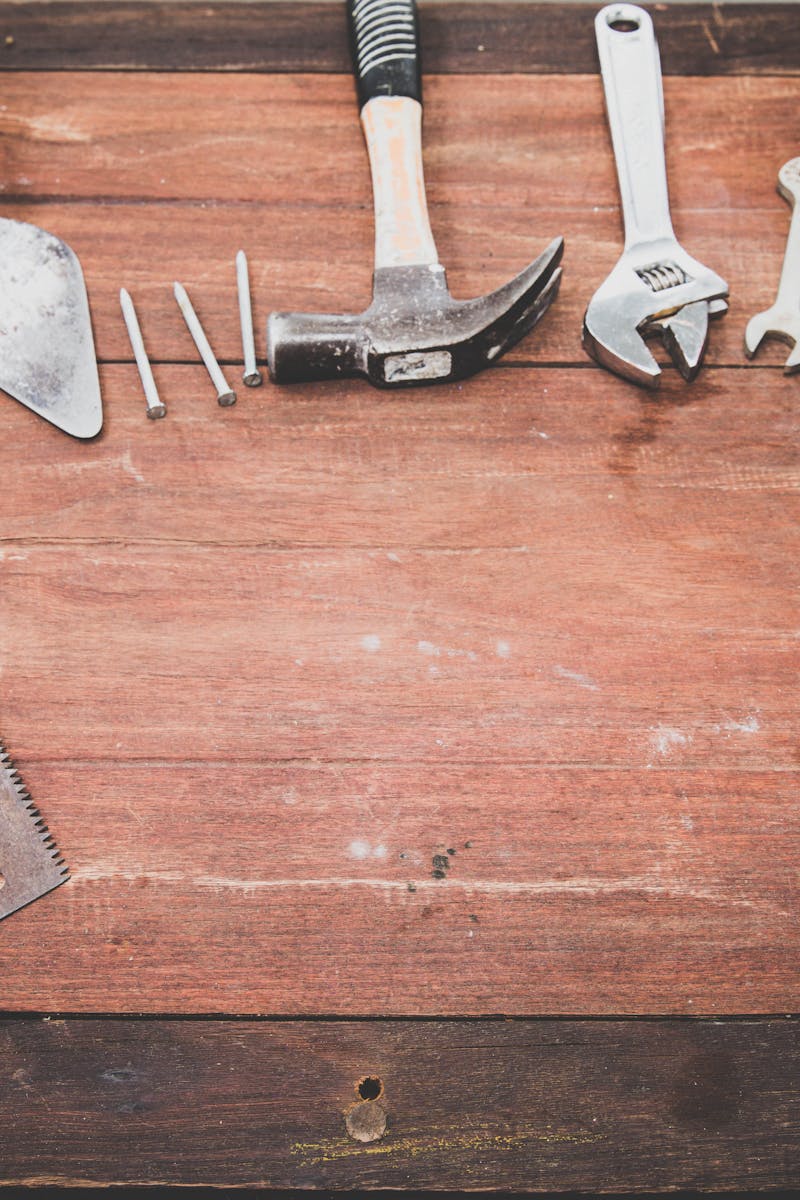 Home Flat lay of various workshop tools on a rustic wooden table, showcasing DIY essentials.